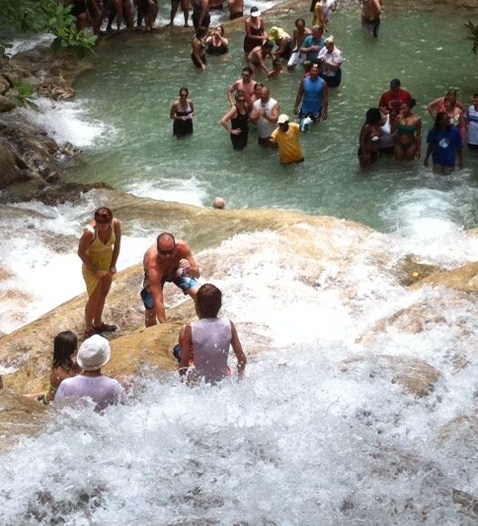 People sitting in water at Dunn's River Falls